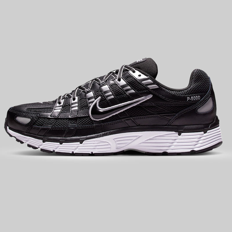 Black running shoe with white sole on a gray background