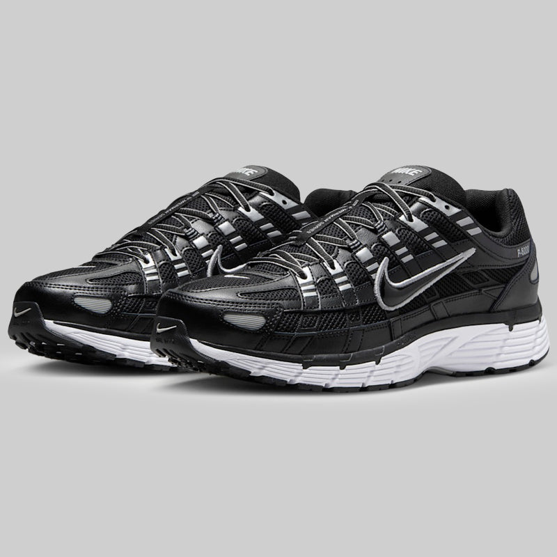 Black running trainers pair with white sole on a gray background