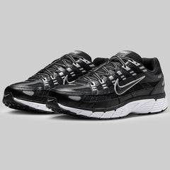 Black running trainers pair with white sole on a gray background