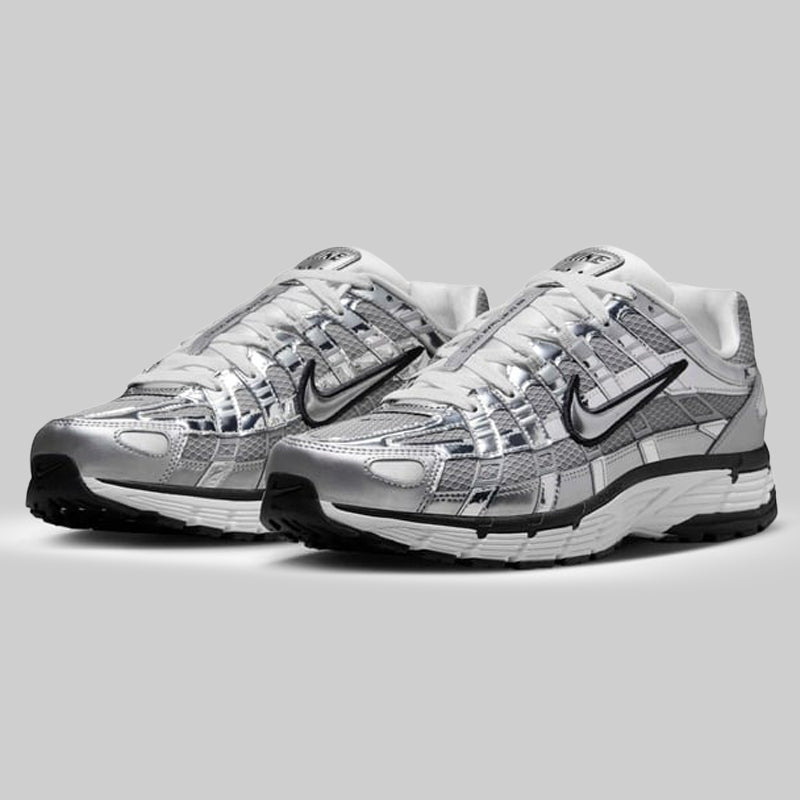 Pair of silver and gray Nike sneakers on a light gray background